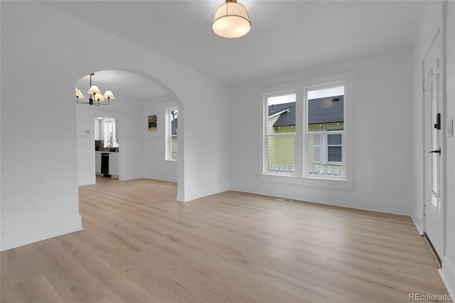 2803 N Cascade Ave, Colorado Springs, CO 80907 - unfurnished living room featuring arched walkways, a chandelier, and light wood finished floors