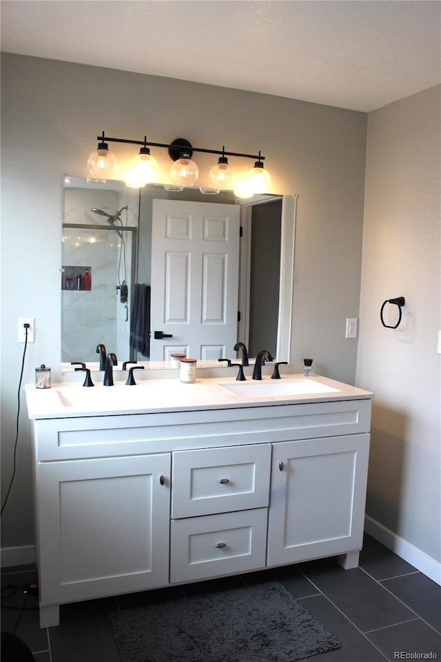 12528 Ash St, Thornton, CO 80241 - full bath featuring tile patterned floors, double vanity, a walk in shower, and baseboards