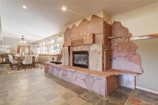 tiled living room featuring a fireplace and ceiling fan