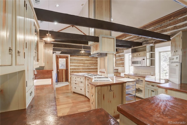 kitchen featuring decorative light fixtures, beam ceiling, plenty of natural light, and white appliances