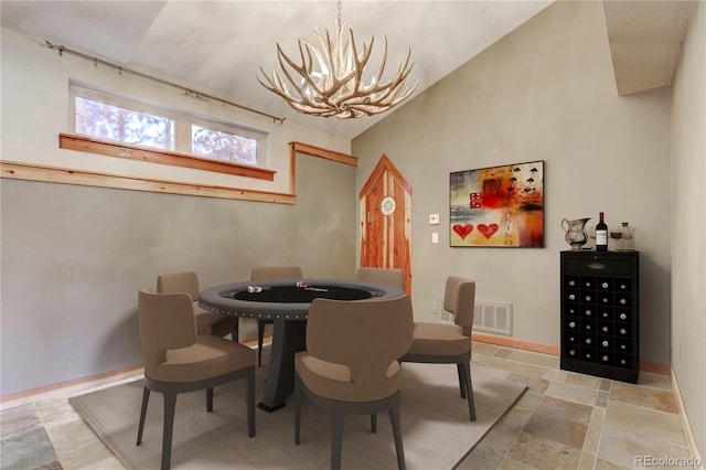 tiled dining area with a chandelier and lofted ceiling