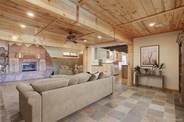 living room with a stone fireplace, tile floors, wood ceiling, and ceiling fan