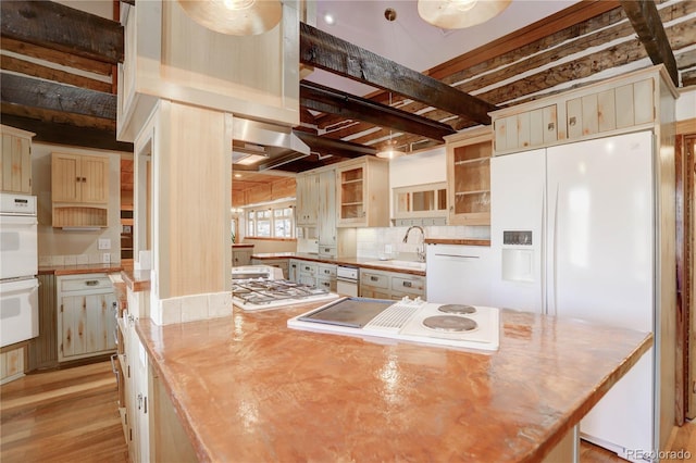 kitchen with tasteful backsplash, white appliances, beamed ceiling, wood-type flooring, and wall chimney exhaust hood