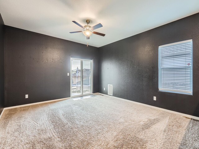 carpeted spare room featuring ceiling fan