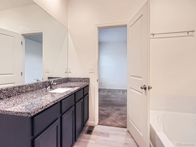 bathroom featuring vanity and a bath