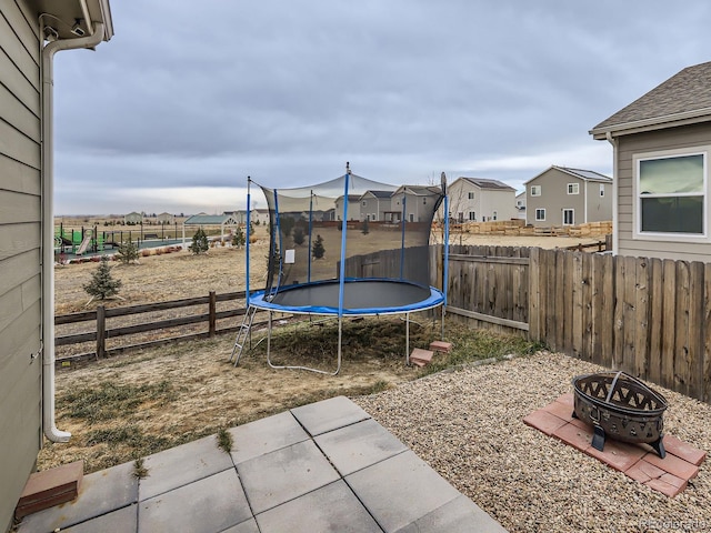 view of yard with a fire pit and a trampoline