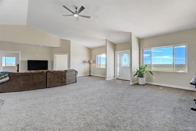 carpeted living area with baseboards, vaulted ceiling, and a ceiling fan