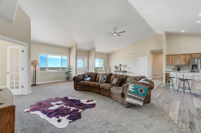 living room with light hardwood / wood-style floors, lofted ceiling, and ceiling fan