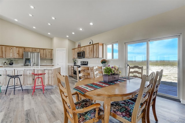 dining area featuring light wood-type flooring, high vaulted ceiling, and recessed lighting