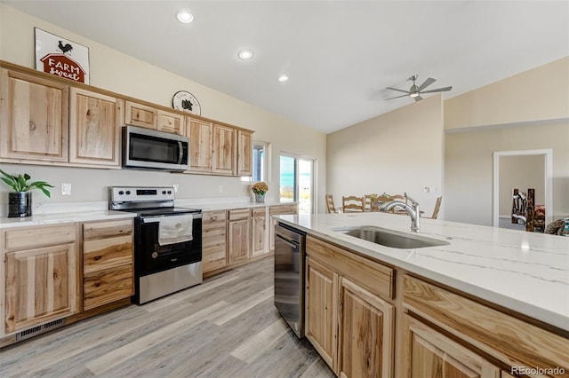 kitchen with ceiling fan, lofted ceiling, sink, appliances with stainless steel finishes, and light wood-type flooring