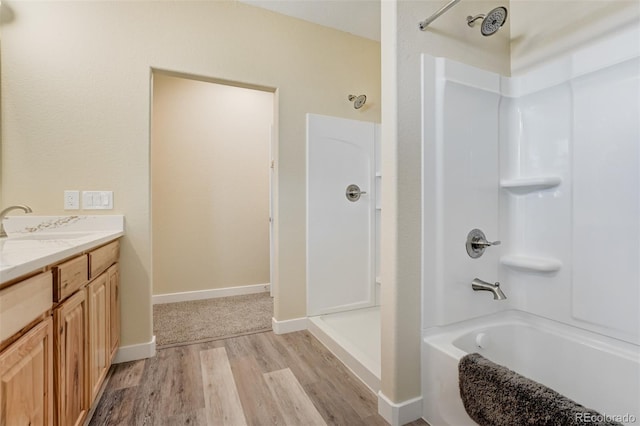 bathroom featuring wood-type flooring, vanity, and bathtub / shower combination