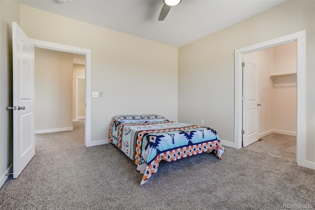 bedroom featuring ceiling fan, light carpet, and a walk in closet