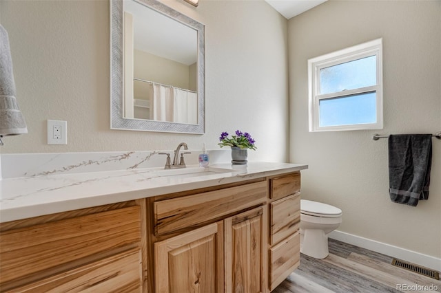 bathroom featuring vanity, hardwood / wood-style floors, and toilet