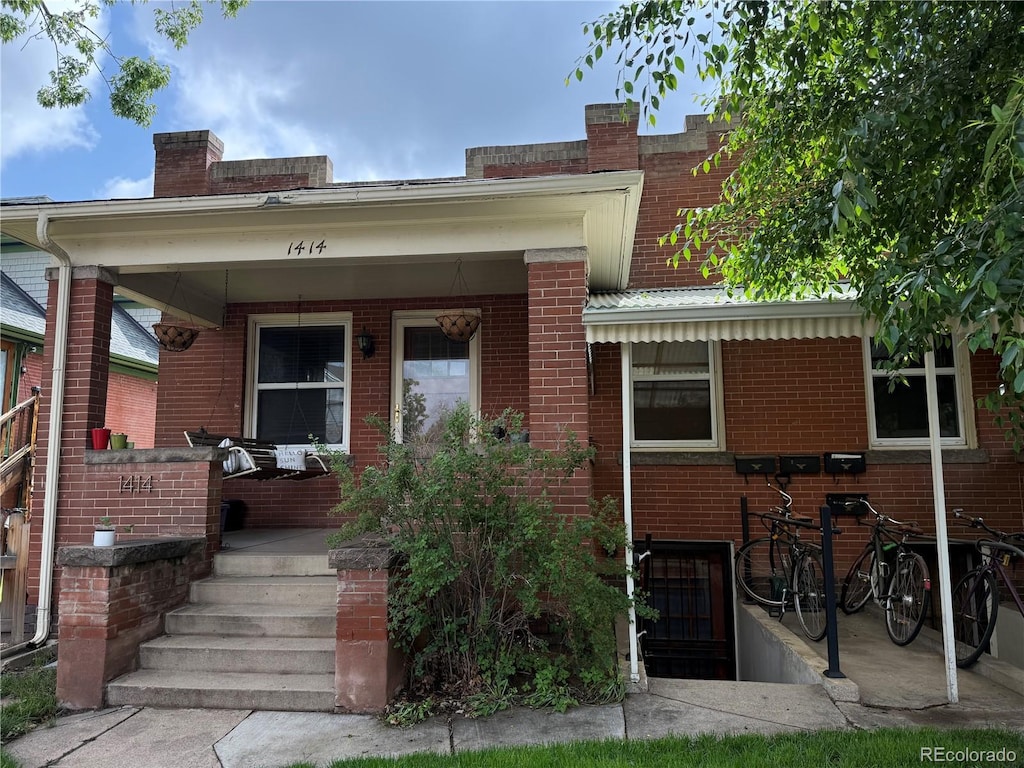 1414 S Pearl St, Denver, CO 80210 - view of front of house featuring a porch, brick siding, and a chimney