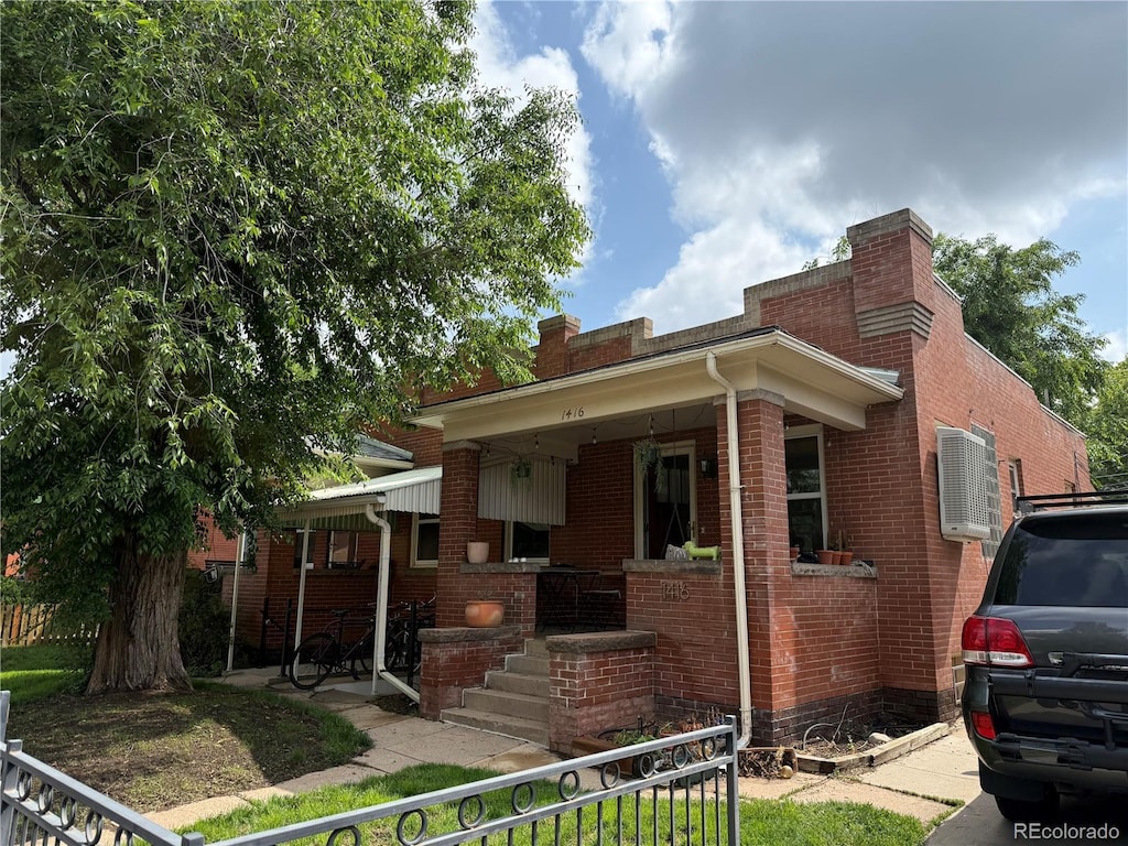 1414 S Pearl St, Denver, CO 80210 - view of front facade featuring a porch, brick siding, and a chimney