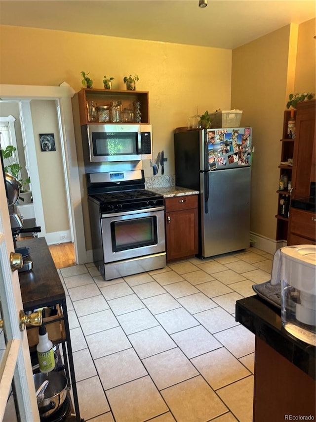 1414 S Pearl St, Denver, CO 80210 - kitchen featuring appliances with stainless steel finishes, light tile patterned floors, and light countertops