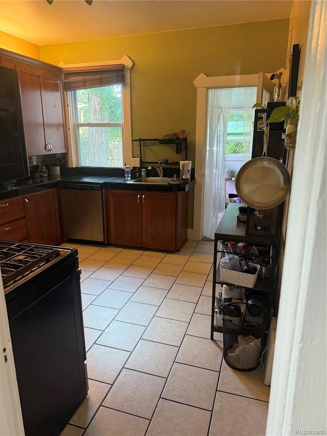 1414 S Pearl St, Denver, CO 80210 - kitchen featuring black range, dark countertops, light tile patterned flooring, dishwasher, and brown cabinetry