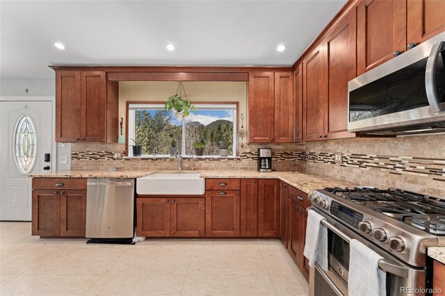 11398 Ranch Elsie Rd, Golden, CO 80403 - kitchen with a wealth of natural light, light stone countertops, stainless steel appliances, and a sink