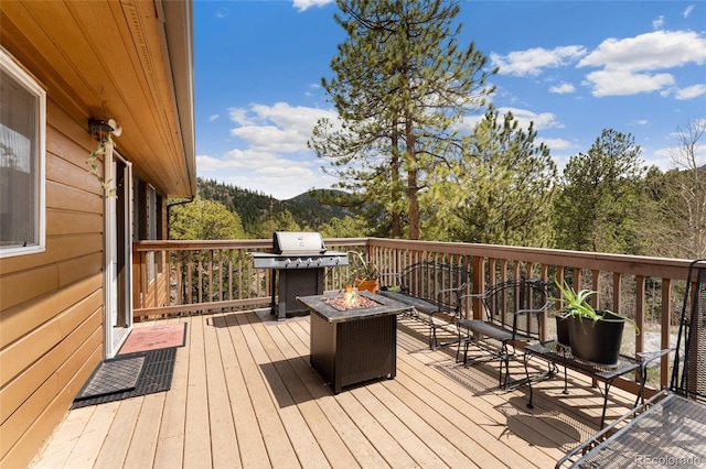 11398 Ranch Elsie Rd, Golden, CO 80403 - wooden terrace with a forest view and an outdoor fire pit