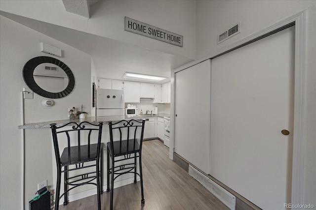 dining space featuring light wood-style flooring and visible vents