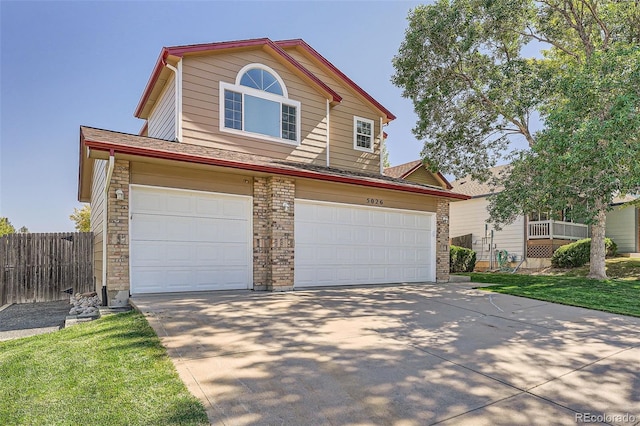 traditional-style house with a garage, fence, and concrete driveway