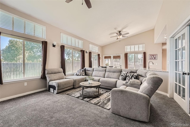 carpeted living area featuring high vaulted ceiling, plenty of natural light, a ceiling fan, and baseboards