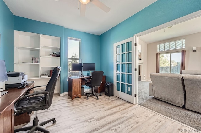 office space featuring ceiling fan, light wood finished floors, and baseboards