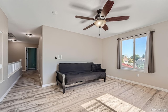 sitting room with baseboards and light wood-style floors