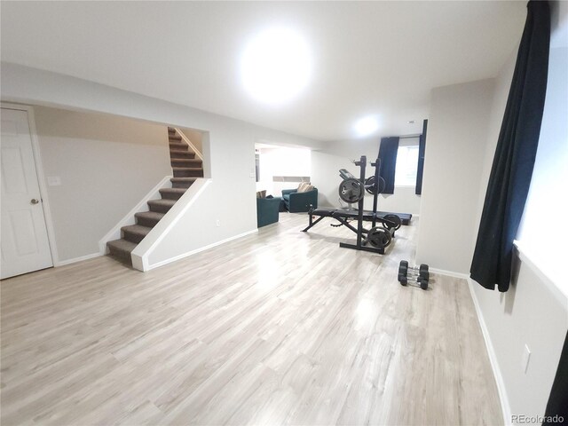 workout room with light wood-type flooring and baseboards