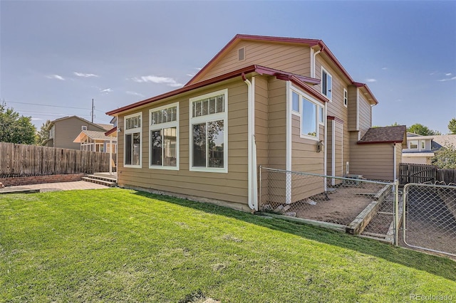 back of property with fence and a lawn