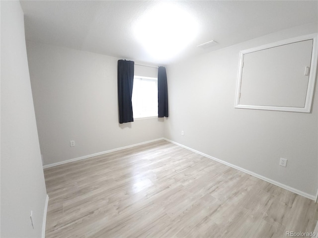 unfurnished room with light wood finished floors and baseboards