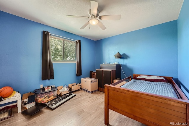 bedroom with ceiling fan, a textured ceiling, and light wood-style floors