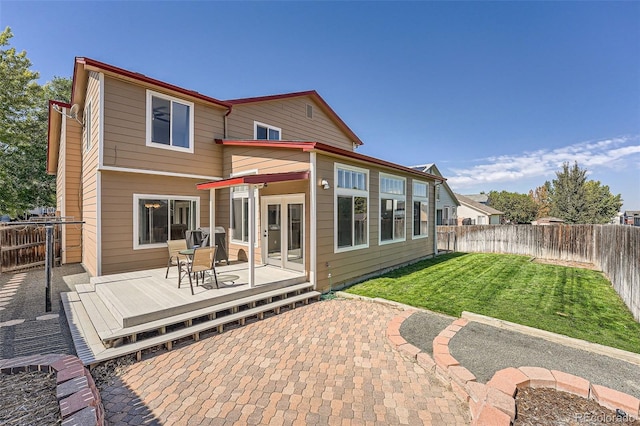 rear view of property with a fenced backyard, a lawn, and a deck