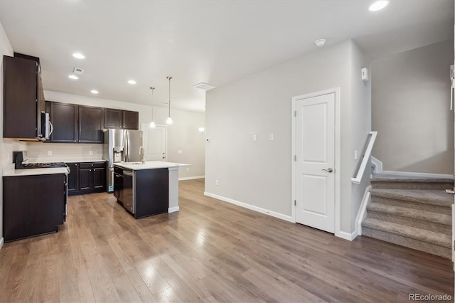 9269 Garnett St Unit C, Arvada, CO 80007 - kitchen featuring light countertops, appliances with stainless steel finishes, a sink, light wood finished floors, and dark brown cabinets