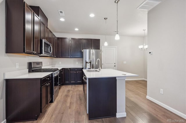9269 Garnett St Unit C, Arvada, CO 80007 - kitchen featuring appliances with stainless steel finishes, a sink, light countertops, dark brown cabinetry, and baseboards