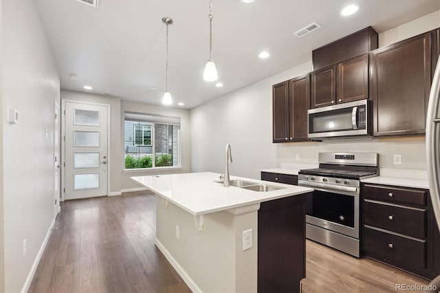 9269 Garnett St Unit C, Arvada, CO 80007 - kitchen with appliances with stainless steel finishes, a sink, light wood finished floors, dark brown cabinetry, and recessed lighting