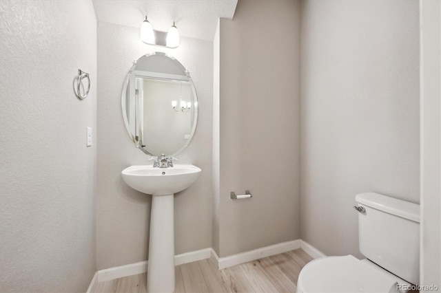 9269 Garnett St Unit C, Arvada, CO 80007 - bathroom featuring toilet, wood finished floors, and baseboards