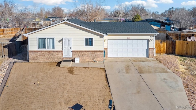 ranch-style home with brick siding, driveway, a garage, and fence