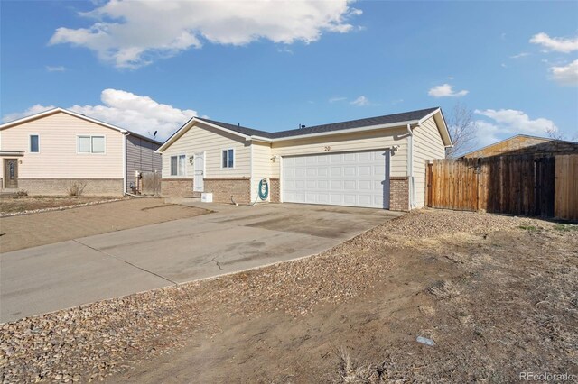 ranch-style house featuring brick siding, driveway, a garage, and fence