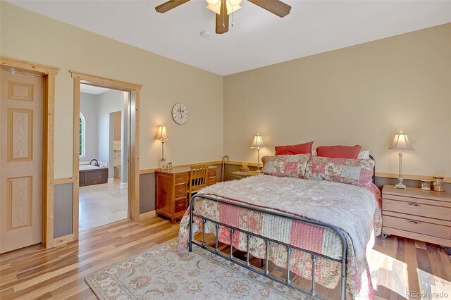 bedroom featuring connected bathroom, ceiling fan, and light hardwood / wood-style flooring