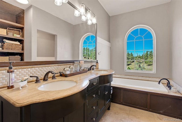 bathroom with backsplash, tile patterned flooring, vanity, and a washtub