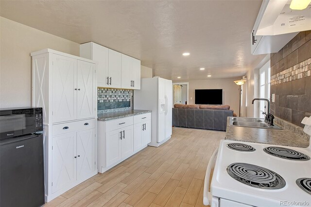 kitchen with white cabinets, sink, white appliances, tasteful backsplash, and light hardwood / wood-style floors