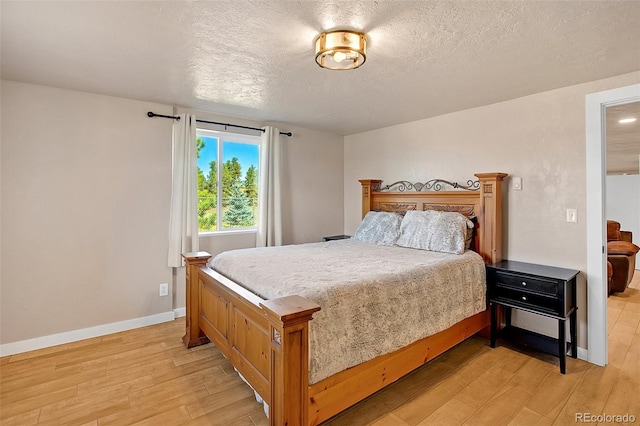 bedroom featuring a textured ceiling and light wood-type flooring