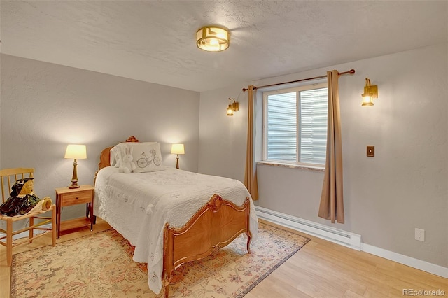 bedroom featuring a baseboard radiator and light hardwood / wood-style flooring