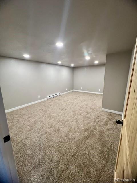 basement featuring carpet floors and a baseboard heating unit