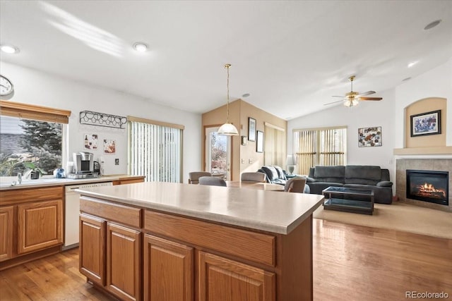 1434 Hickory Dr, Erie, CO 80516 - kitchen with ceiling fan, dishwasher, vaulted ceiling, a kitchen island, and a tile fireplace