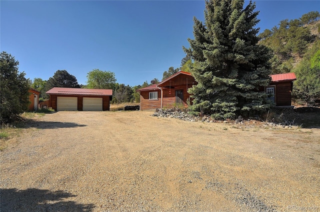 view of front of house with a garage and a shed