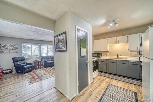 kitchen with white cabinetry, sink, white appliances, light hardwood / wood-style flooring, and gray cabinetry