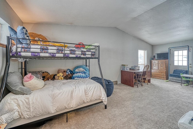 bedroom with a textured ceiling, lofted ceiling, and carpet floors