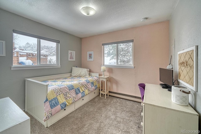 carpeted bedroom featuring a baseboard heating unit and a textured ceiling